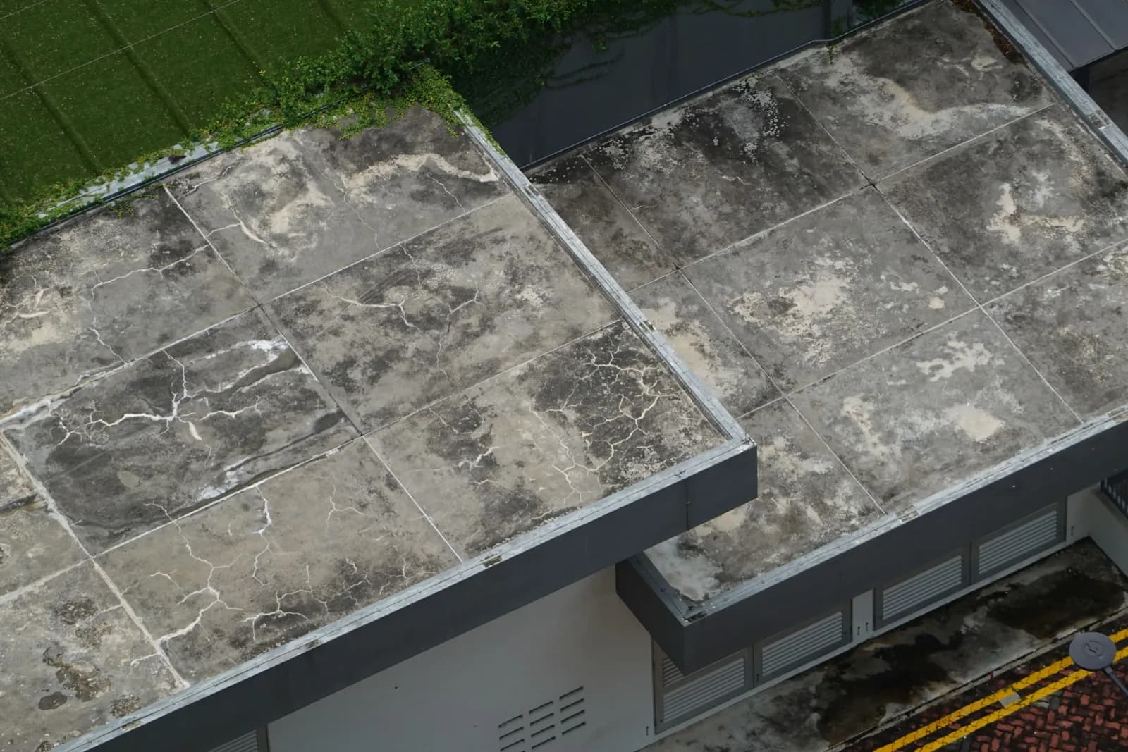 Dak beton gedung yang retak, berjamur, dan lapisan permukaannya mengelupas